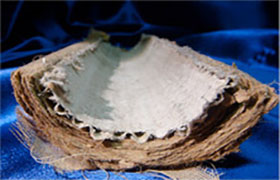 A bowl of white fabric on top of a blue cloth.